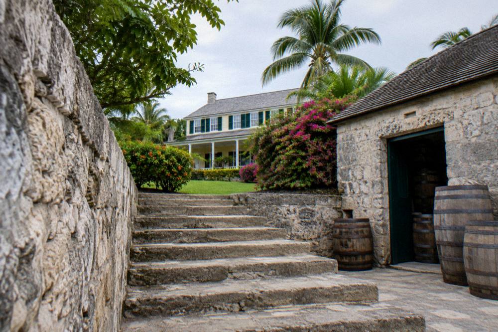 Stone estate building of a Nassau rum distillery surrounded by tropical gardens